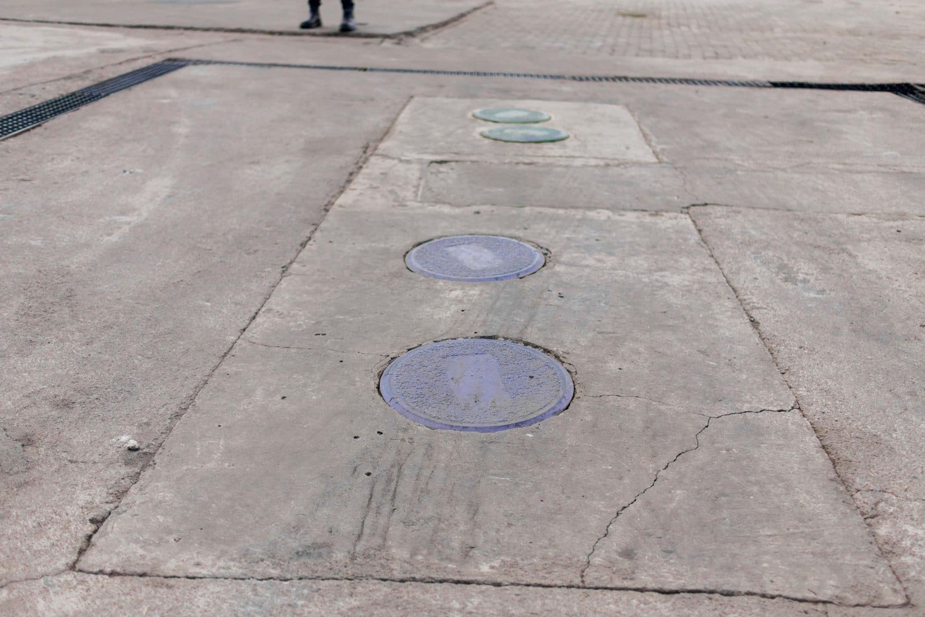 Inspection covers set flush into a forecourt slab